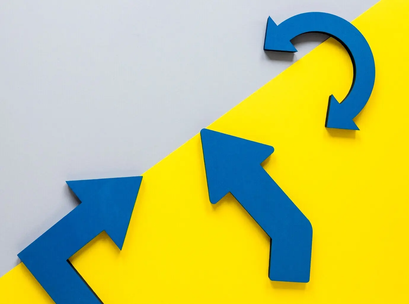 Draufsicht mit blauen Pfeilen und gelbem Karton auf weißem Hintergrund.