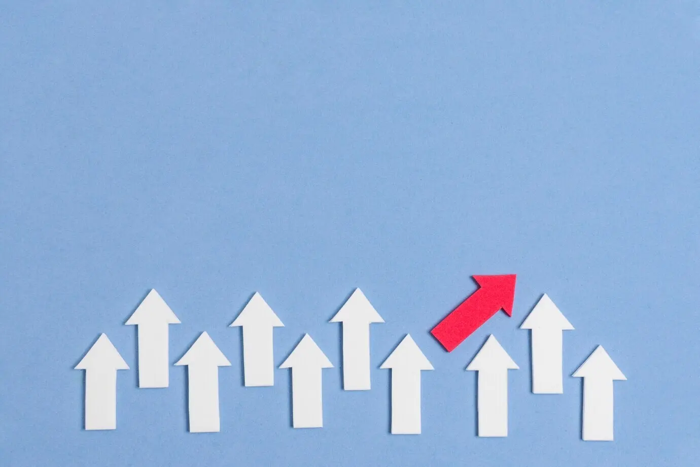 Markanter roter Pfeil und weiße Pfeile inmitten einer Menge.