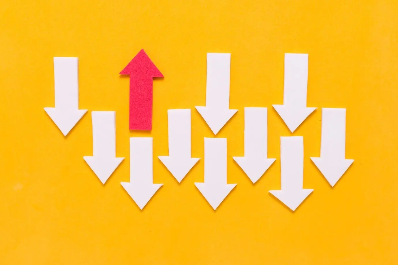 Rebellischer roter Pfeil und eine Ansammlung weißer Pfeile in verschiedenen Richtungen